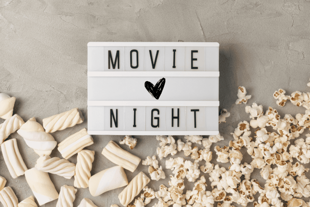 Petiscos para uma noite de filmes romanticos em casal. Pipocas e marshmallows. 
E uma placa enfeitada, com a frase: "movie night"