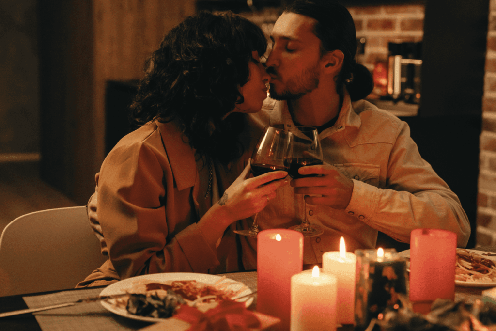 casal brindando em jantar romântico em casa. Mesa de jantar e velas.