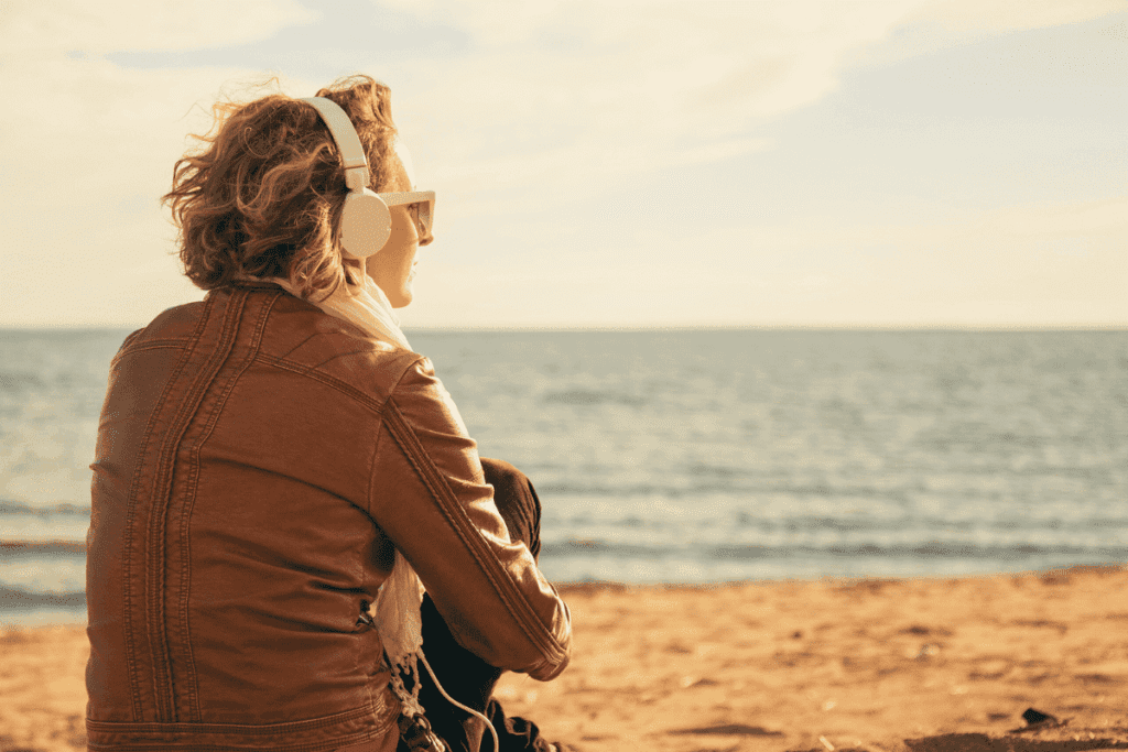 foto de mulher ouvindo música a beira mar