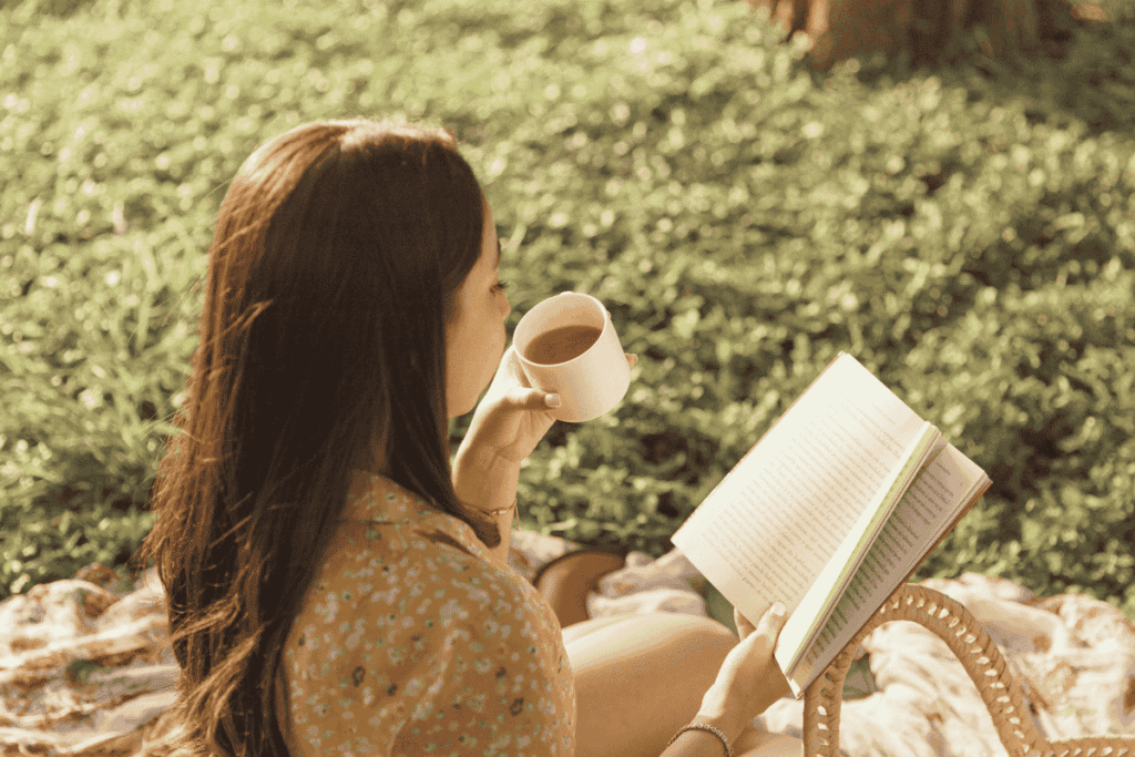 mulher lendo um livro e tomando chá