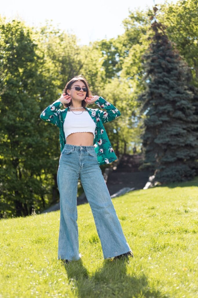 mulher com calça jeans flare, bata e kimono floral. moda boho chic com jeans.